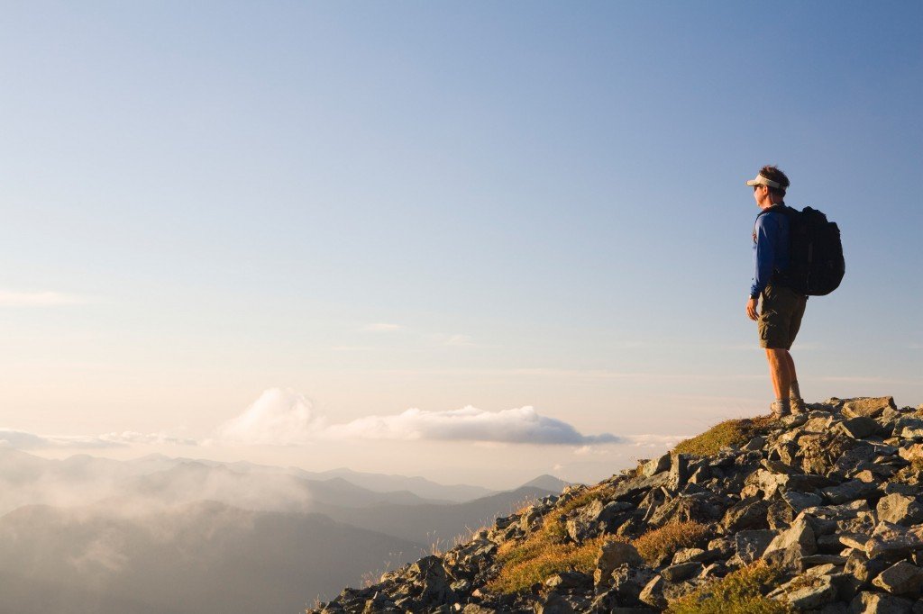 USA, Washington, man on mountaintop at dusk, side view